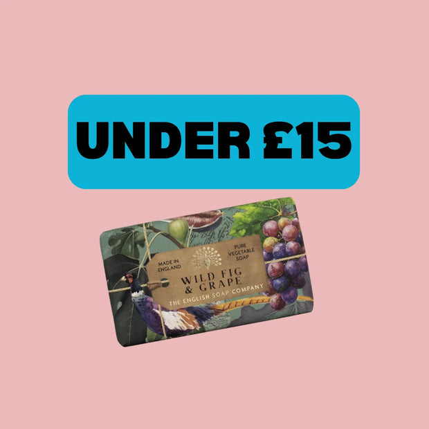 A rectangular gift card for Wild Fig & Grape by The Engaged Food Company, featuring an artistic illustration of a bird, grapes, and leaves, set against a solid pink background with a blue banner above that reads 'UNDER £15'.
