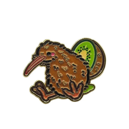 A kiwi bird enamel pin with a brown body, orange beak and feet, and a green kiwi slice on its back, shown on a plain white background.