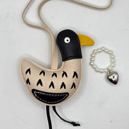 a bird bag charm with a necklace