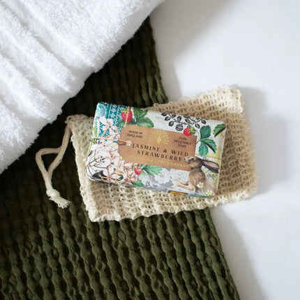 Bar of soap with floral packaging on a textured green surface