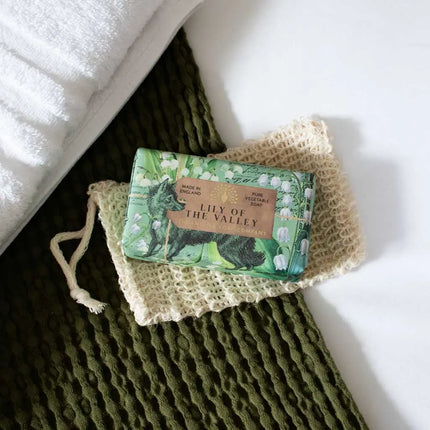 Bar of soap with 'Lily of the Valley' packaging on a textured green surface